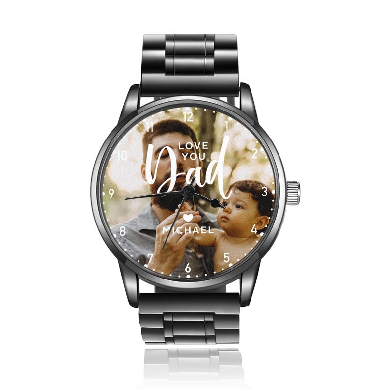 May include: A black wristwatch with a metal band and a round face. The watch face features a photo of a man and a child, with the words "LOVE YOU Dad" and the name "MICHAEL" in white script. The watch has a silver crown.