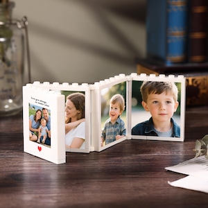 May include: A white photo display made of interlocking blocks, showcasing family photos. The display features a red heart and the text "Love you always, no matter what." The photos depict a family of three and a young child.
