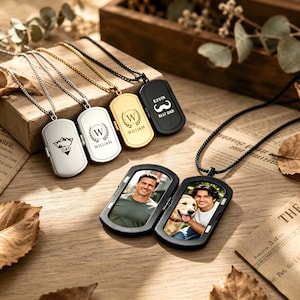 Puede incluir: Una colección de collares con placas de identificación y cadenas de metal. Tres placas cerradas presentan grabados: una montaña con 'DAD', una 'W' en una corona con 'WILLIAM' y un bigote con 'KEVIN BEST DAD'. Una placa negra abierta muestra dos fotos.