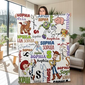 May include: White blanket featuring various Toy Story characters and the name "Sophia" in multiple fonts and colors. The blanket includes images of Woody, Buzz Lightyear, Jessie, and other characters from the movie.