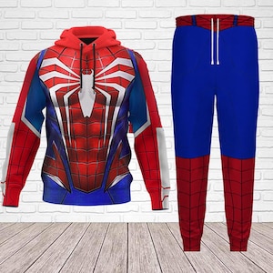 May include: A red, blue, and white Spider-Man themed hoodie and matching pants set. The hoodie features a large spider emblem on the chest and back. The pants are blue with red accents.