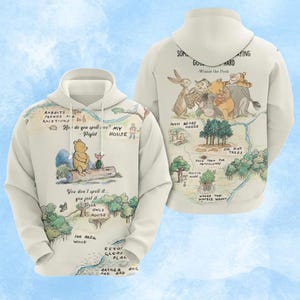 May include: A cream-colored hoodie featuring a map of the Hundred Acre Wood with Winnie the Pooh and Piglet on the front. The back displays a group of characters with the text, "Sometimes the smallest things take up the most room in your heart."