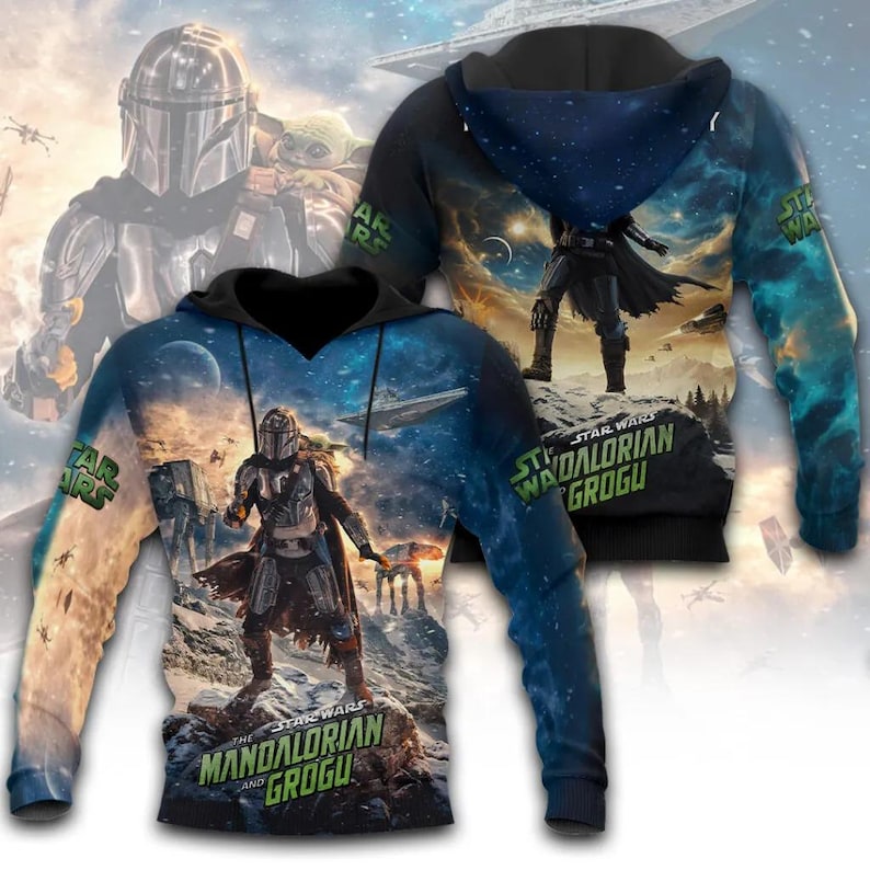 May include: A hooded sweatshirt with a design from "The Mandalorian" series. The front shows the Mandalorian character on a rocky surface, with the text "The Mandalorian and Grogu". The sleeves and back show space scenes and other characters.