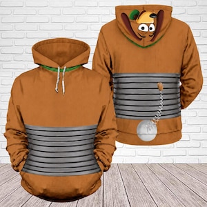 May include: A brown hoodie featuring a graphic print of a cartoon dog character. The design includes a grey horizontal ribbed pattern across the midsection, a hood with dog ears, and a small white ball attached by a spring on the back.