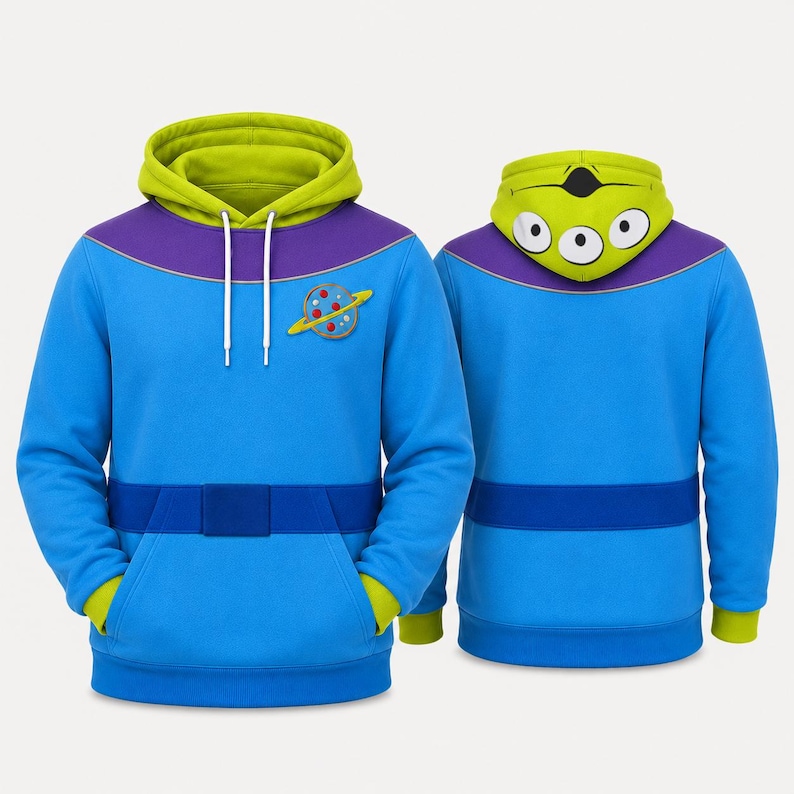Puede incluir: Una sudadera con capucha azul que presenta una capucha verde lima con un gr&aacute;fico de cara de alien&iacute;gena de tres ojos, un panel morado en el pecho, un parche de planeta en el lado izquierdo y un gr&aacute;fico de cintur&oacute;n azul oscuro en la cintura.