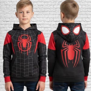 May include: Black hooded sweatshirt with a red and black spider web design. The front features a large red spider emblem, and the back of the hood has white eye shapes. The sleeves and shoulders are red.