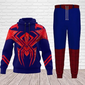 May include: A blue hoodie and matching pants set. The hoodie features a large red spider emblem on the front and shoulders. The pants are blue with red panels on the lower legs. The drawstring on the pants is white.
