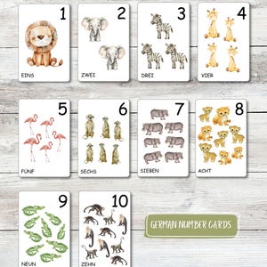 Puede incluir: Juego de diez tarjetas didácticas con ilustraciones de animales y números del 1 al 10. Cada tarjeta muestra un número y la cantidad correspondiente de animales, como un león para el '1' y cebras para el '3'. También está el texto 'German Number Cards'.