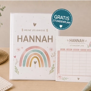 May include: A white folder labeled MEINE ZEUGNISSE HANNAH with a pastel rainbow and floral design, accompanied by a matching weekly schedule card labeled HANNAH STUNDENPLAN, featuring a teal circular sticker that reads GRATIS STUNDENPLAN.