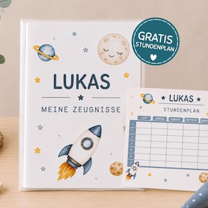 May include: A white folder labeled LUKAS MEINE ZEUGNISSE with a space theme featuring a rocket, planets, and stars, accompanied by a matching weekly schedule card labeled LUKAS STUNDENPLAN with a blue grid and space-themed illustrations.