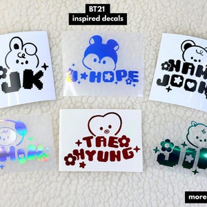 Könnte beinhalten: BT21-inspirierte Aufkleber mit Cartoon-Charakteren und Namen. Die Aufkleber enthalten die Namen "JK", "J-HOPE", "NAM JOON", "JIMIN", "TAE HYUNG" und "JIN". Die Aufkleber sind in verschiedenen Farben erhältlich, darunter Schwarz, Blau und Rot.