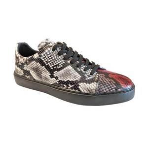 May include: A single sneaker with a snakeskin pattern in black, white, and red. The shoe has black laces and a black sole. The toe of the shoe is red.