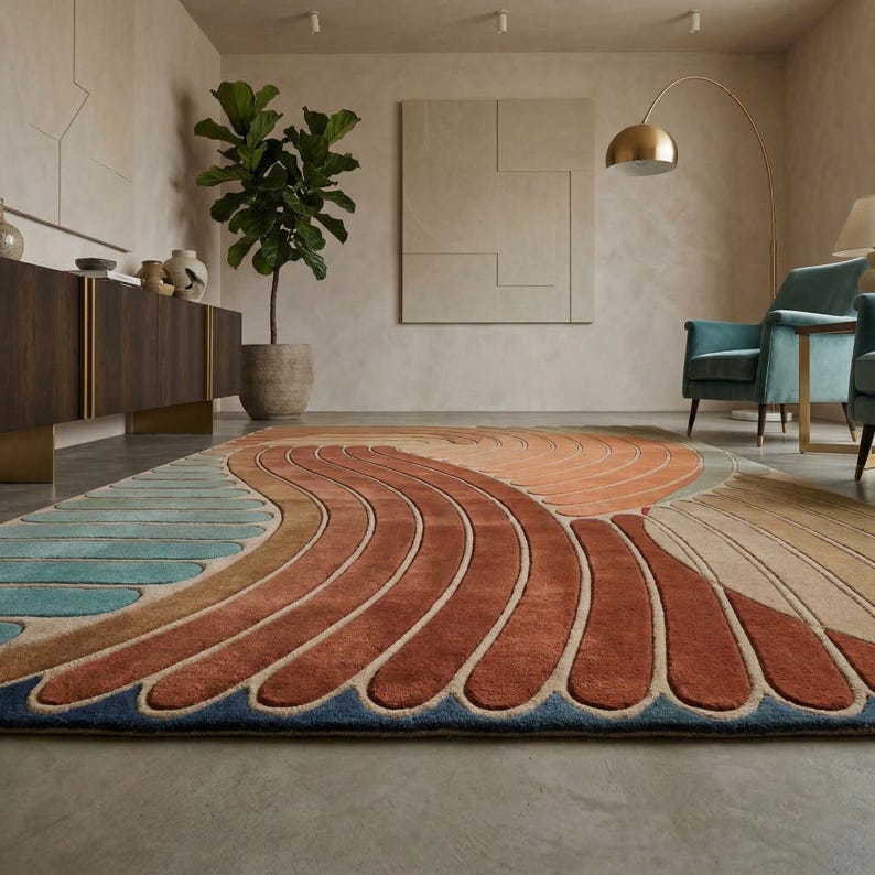 May include: A large, rectangular area rug with an abstract design in shades of blue, orange, and brown. The rug features a wave-like pattern with curved lines and a textured appearance, suitable for a living room or bedroom.