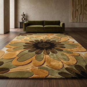 Puede incluir: Una alfombra rectangular grande con un dise&ntilde;o floral en tonos marrones, verdes y beige. La alfombra est&aacute; colocada sobre un suelo de madera oscura, con un sof&aacute; verde en el fondo. El patr&oacute;n de la alfombra se asemeja a una flor grande.