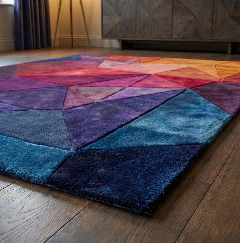 K&ouml;nnte beinhalten: Ein farbenfroher geometrischer Teppich mit einem Farbverlauf von Blau-, Lila-, Rot-, Orange- und Gelbt&ouml;nen. Der Teppich besteht aus einem weichen, pl&uuml;schigen Material und weist ein modernes, abstraktes Design auf. Der Teppich ist rechteckig.