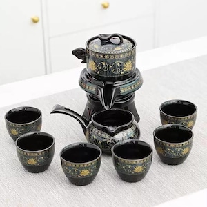 Può includere: Servizio da tè in ceramica nera con decorazioni floreali dorate. Il set include una teiera con coperchio, una brocca e sei piccole tazze. Il set da tè ha un design tradizionale asiatico.
