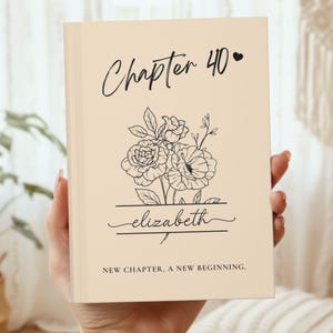 May include: A beige book cover with the text "Chapter 40" and a heart symbol. Below, a floral illustration and the name "elizabeth" are featured. The bottom of the cover reads "NEW CHAPTER, A NEW BEGINNING."