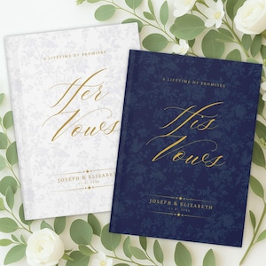 Op de afbeelding: Twee trouwgeloftenboeken. Eén is wit met een bloemenpatroon en gouden belettering met de tekst "Her Vows". De andere is marineblauw met een bloemenpatroon en gouden belettering met de tekst "His Vows". Beide boeken hebben bovenaan de tekst "A Lifetime of Promises".