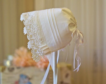 Beautiful white cotton baby bonnet edged with heavy lace and tucks. Cotton Cottagecore baby cap.