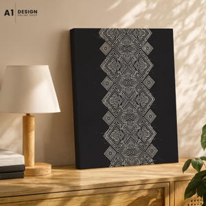 May include: A rectangular canvas wall art piece featuring a solid black background with a vertical central band of white geometric patterns consisting of interconnected diamonds and intricate line work, displayed in a room setting.