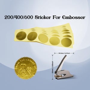 May include: A silver embosser with a black handle, next to a gold seal and sheets of gold stickers. The text "200/400/600 Sticker For Embosser" is at the top. The embosser is 2.05 inches tall and 4.67 inches wide.