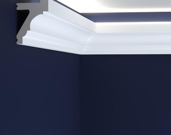 May include: A section of white crown molding installed in a corner where the wall meets the ceiling. The molding has a curved design and is against a dark blue wall. The ceiling is white with a recessed light.