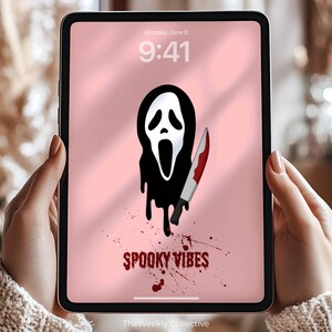 Puede incluir: Una tableta digital muestra una pantalla rosa con un gr&aacute;fico de m&aacute;scara de Scream en blanco y negro sosteniendo un cuchillo ensangrentado. Las palabras "Spooky Vibes" est&aacute;n escritas en rojo. La hora es 9:41, lunes 6 de junio.