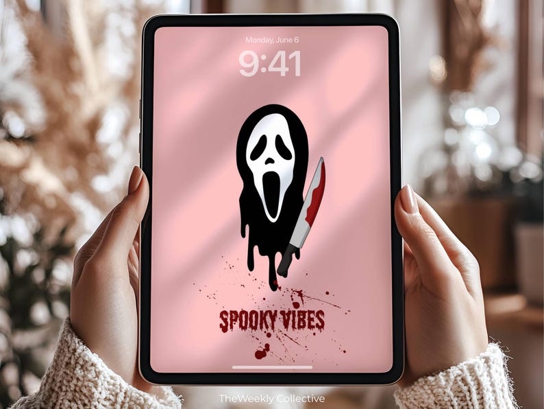 Puede incluir: Una tableta digital muestra una pantalla rosa con un gr&aacute;fico de m&aacute;scara de Scream en blanco y negro sosteniendo un cuchillo ensangrentado. Las palabras "Spooky Vibes" est&aacute;n escritas en rojo. La hora es 9:41, lunes 6 de junio.