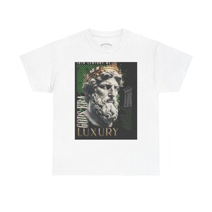 Könnte beinhalten: Weißes T-Shirt mit einer Grafik einer klassischen Büste mit goldenem Kranz, vor schwarzem und grünem Hintergrund. Die Worte "GODS ERA" und "LUXURY" sind auf dem Design aufgedruckt. Ein stilvolles T-Shirt für Kunstliebhaber.