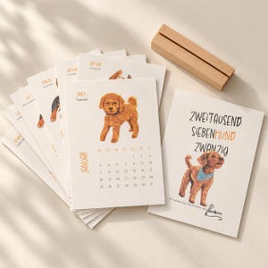 May include: A set of paper calendar pages featuring watercolor-style dog illustrations, including a brown toy poodle and a dog wearing a blue bandana. The text includes 'ZWEITAUSEND SIEBENHUND ZWANZIG' and 'JANUAR'. A rectangular wooden stand is included.