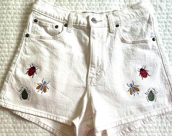 Cute Upcycled Cream Denim Abercrombie Noah Kahan Bugs inspired embroidered shorts. 26” waist