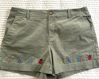 Gerecyclede, met mosgroene insecten geïnspireerde, geborduurde shorts, taille 86 cm. Maat 10