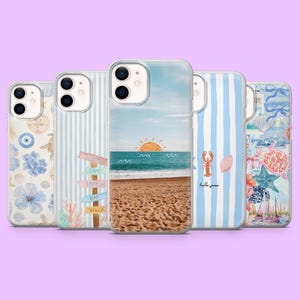 May include: Five smartphone cases featuring various coastal designs. The first has blue flowers and shells, the second shows beach signs, the third depicts a sunset over the ocean, the fourth has blue stripes with a lobster, and the fifth shows sea life.