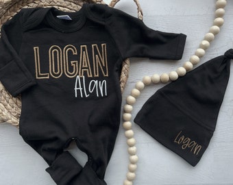Puede incluir: Mono negro para bebé con bordado dorado que dice "LOGAN Alan". También se incluye un gorro negro a juego con bordado dorado que dice "Logan".