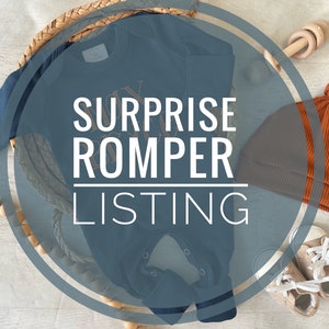 May include: A blue baby romper with the text "Surprise Romper Listing" in a circle. The romper is surrounded by a wooden bead garland, a wooden toy, a brown knitted hat, and two pairs of beige baby shoes.