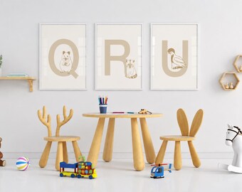 Puede incluir: Tres cuadros de pared enmarcados con las letras Q, R y U junto a ilustraciones de un hámster, un mapache y un pelícano. El conjunto se exhibe sobre una mesa infantil de madera con dos sillas, una con astas de ciervo y otra con orejas de conejo.