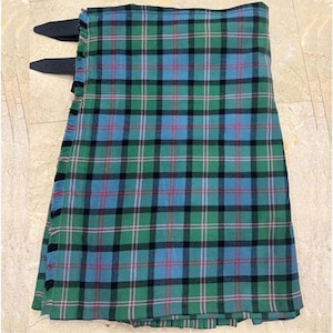 Könnte beinhalten: Ein grüner, blauer und schwarzer Schottenkilt mit zwei schwarzen Lederriemen. Der Kilt hat ein traditionelles Tartanmuster mit grünen, blauen, schwarzen und rosa Linien. Der Kilt ist gefaltet und aus einem gewebten Stoff gefertigt.