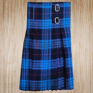 May include: A blue tartan kilt with red lines and silver buckles. The kilt has a pleated design and a traditional pattern. This garment is suitable for various occasions.