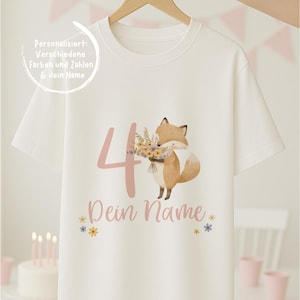 Puede incluir: Camiseta blanca con una ilustración de un zorro sosteniendo flores, el número 4 y el texto "Dein Name". La camiseta también tiene el texto "Personalisierst: Verschiedene Farben und Zahlen & dein Name".