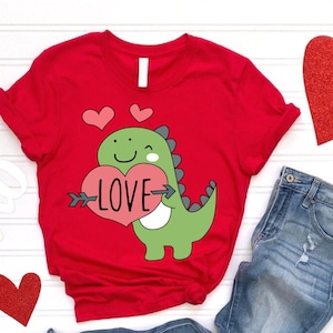 Cute Valentine Dinosaur Shirt, Red T-Shirt with Green Dino Holding Heart, Love Graphic Tee for Valentine’s Day Gift, Valentine’s Day Outfit