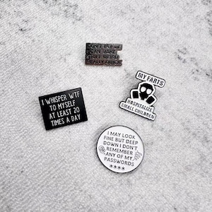 Puede incluir: Cuatro pines de esmalte con frases humorísticas. Un pin dice "DON'T TRY ME I CAN MAKE STUFF WEIRD REALLY QUICK". Otro dice "I WHISPER WTF TO MYSELF AT LEAST 20 TIMES A DAY". Los otros dos pines dicen "MY FARTS HOSPITALIZE SMALL CHILDREN" y "I MAY LOOK FINE BUT DEEP DOWN I DON'T REMEMBER ANY OF MY PASSWORDS ****."