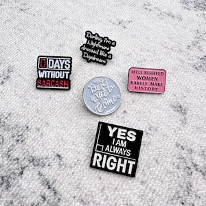 Snygga emaljnålar med kvicka, inspirerande och stärkande citat, perfekta för att ge mening åt dina väskor, jackor