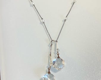 Peut inclure: Un collier délicat en chaîne argentée avec des perles de cristal claires et deux gouttes de cristal pendantes.
