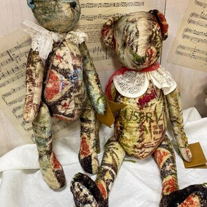 Puede incluir: Dos osos de peluche hechos a mano con tela vintage. Los osos tienen cuerpos estampados en tonos crema, marr&oacute;n, rojo y azul. Llevan cuellos de encaje y tienen rasgos faciales cosidos. Un oso tiene una oreja azul y el otro un cuello rojo.