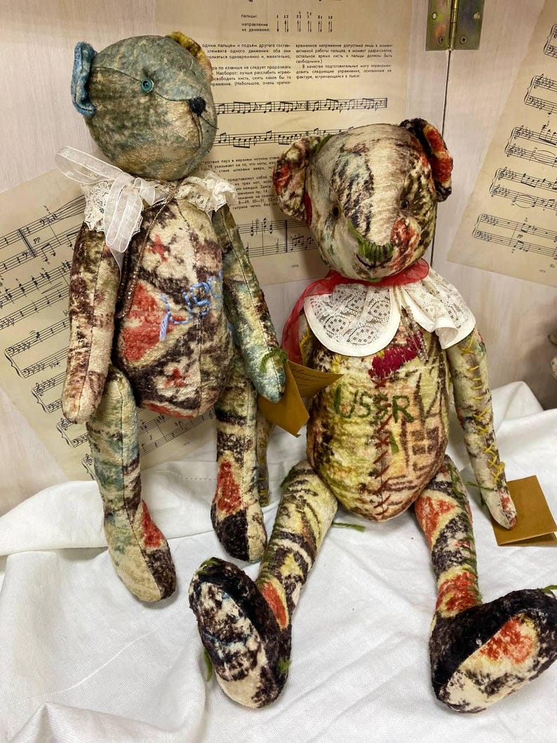 Puede incluir: Dos osos de peluche hechos a mano con tela vintage. Los osos tienen cuerpos estampados en tonos crema, marr&oacute;n, rojo y azul. Llevan cuellos de encaje y tienen rasgos faciales cosidos. Un oso tiene una oreja azul y el otro un cuello rojo.