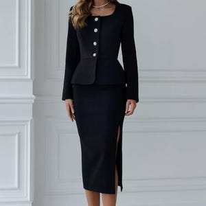 May include: A black skirt suit with a peplum jacket and a knee-length skirt with a side slit. The jacket has a square neckline and is fastened with three large, round buttons. The text "ShariUa" is visible at the bottom of the image.