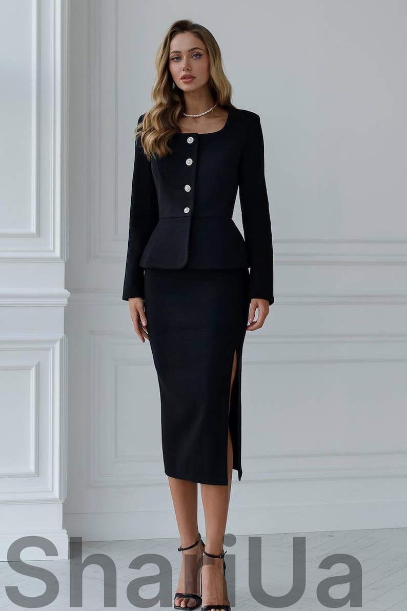 May include: A black skirt suit with a peplum jacket and a knee-length skirt with a side slit. The jacket has a square neckline and is fastened with three large, round buttons. The text "ShariUa" is visible at the bottom of the image.