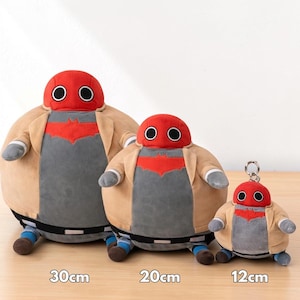 May include: Three plush figures of a character with a red head and large black eyes, wearing a tan jacket and gray shirt with a red emblem. The largest is 30cm tall, the middle one is 20cm, and the smallest is 12cm and a keychain.