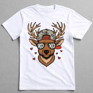 May include: White t-shirt featuring a cartoon deer head wearing sunglasses with "XO" on the lenses, a camouflage baseball cap, and red hearts. The deer has brown antlers and fur. A red brim is visible on the cap.