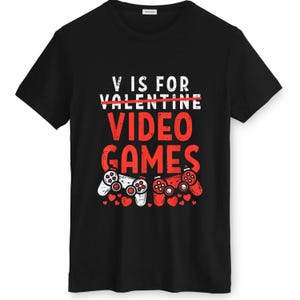 May include: Black t-shirt with a graphic design. The design features the text "V IS FOR VIDEO GAMES" in white and red, with two game controllers and small red hearts.